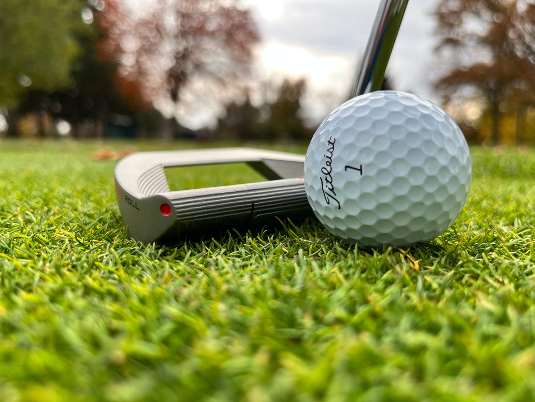 How does a putter apply roll to the golf ball?