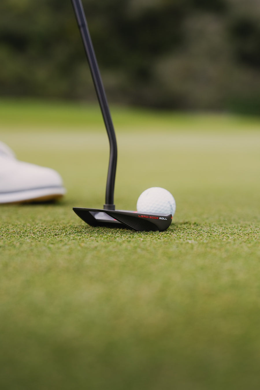 A ball rolling away from a Spoiler putter on the green