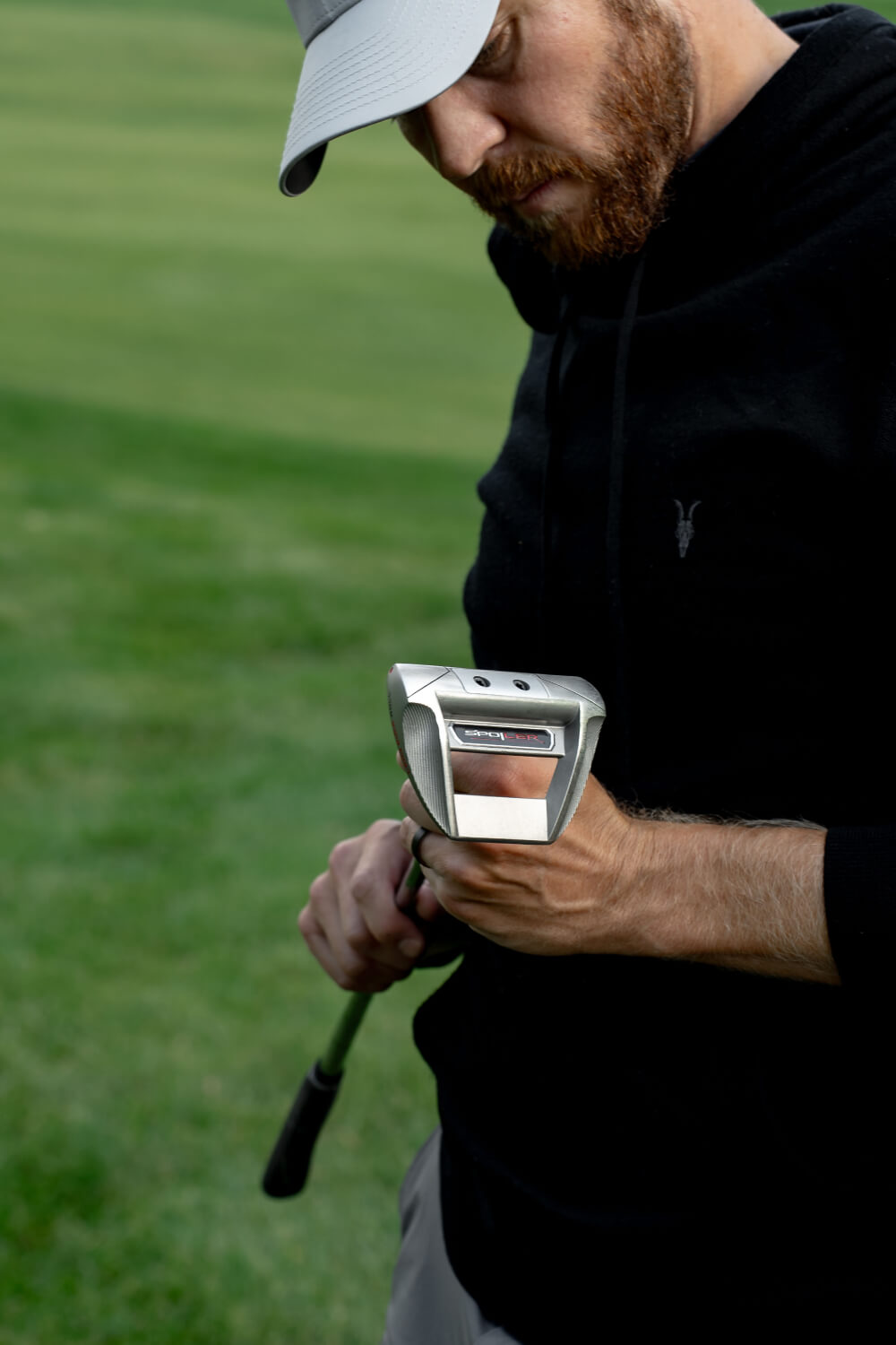 a man inspecting a Spoiler putter